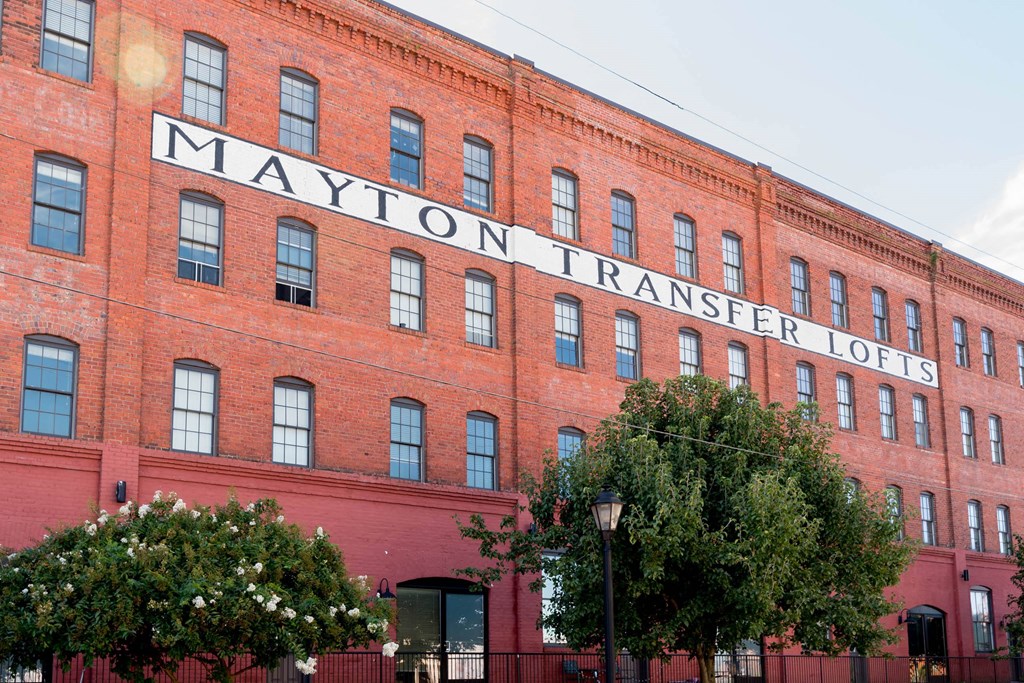 a large brick building with a sign on the side of it at Mayton Transfer Lofts, Petersburg Virginia