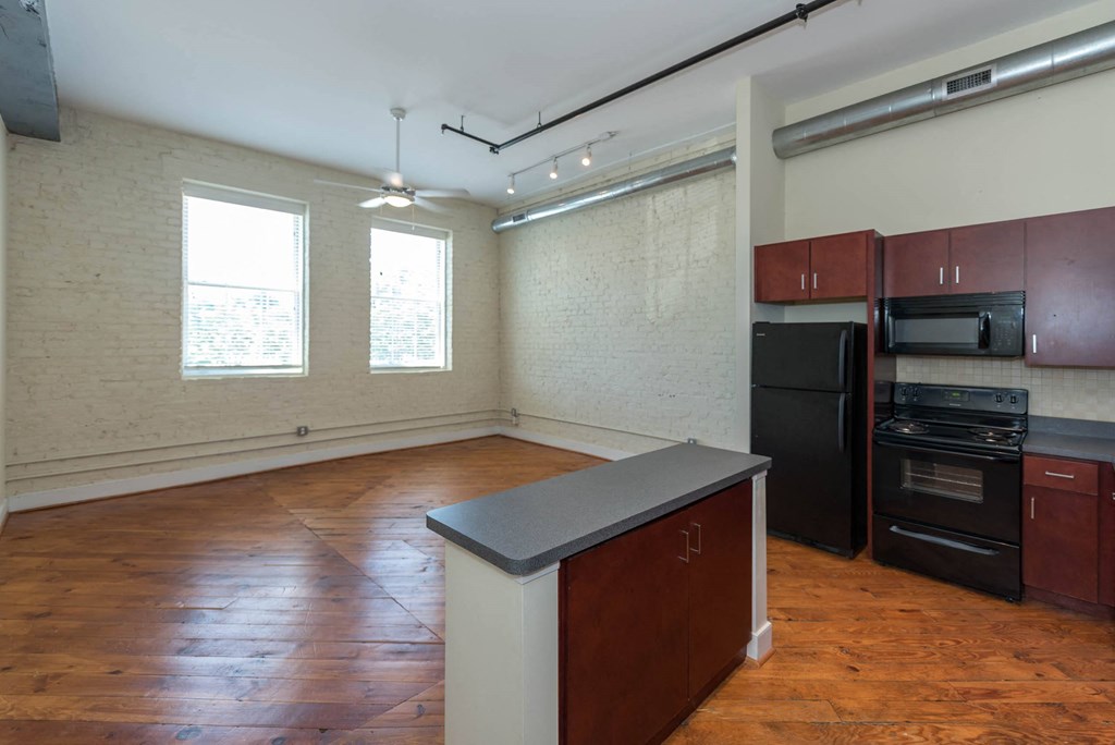 an empty kitchen with an island in the middle of it at Mayton Transfer Lofts, Petersburg Virginia