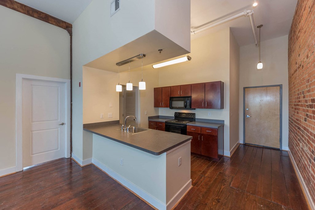 an empty kitchen with a counter top and a sink at Mayton Transfer Lofts, Petersburg, VA