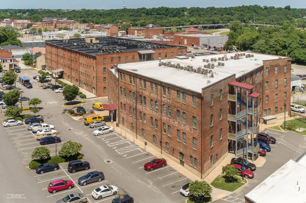 an aerial view of an apartment building in a parking lot at Mayton Transfer Lofts, Petersburg, 23803
