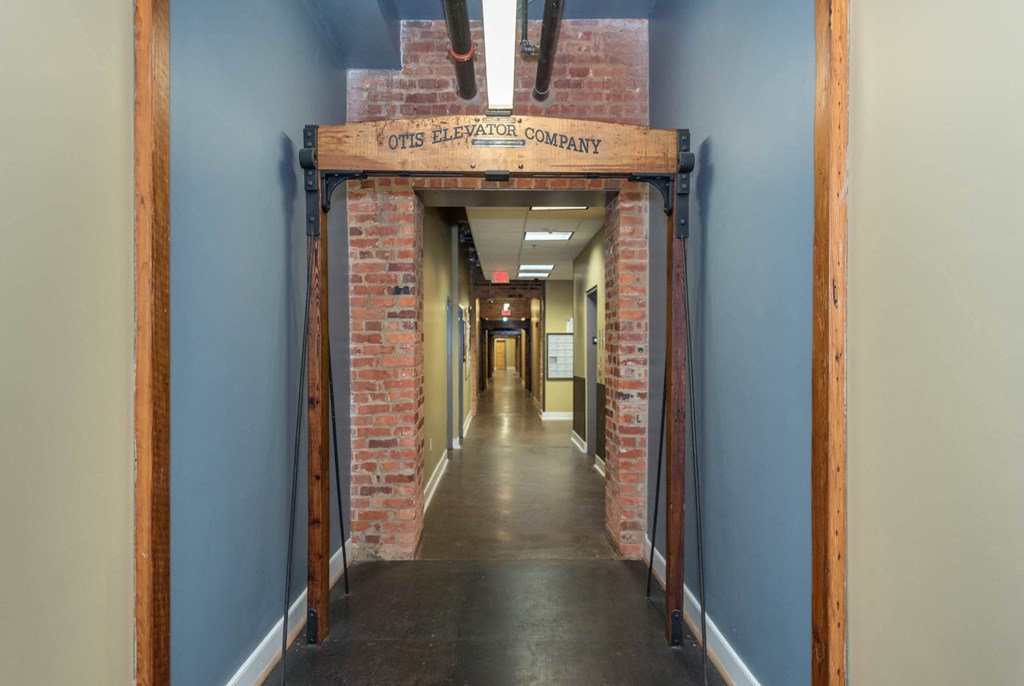 a hallway with a brick doorway with a sign above it at Mayton Transfer Lofts, Petersburg