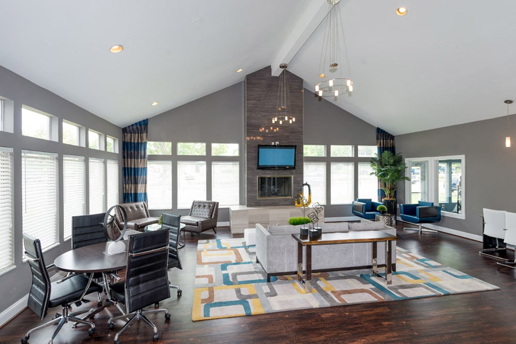 a large living room with gray walls and hardwood flooring topped by a colorful area rug at Misty Ridge Apartments, Woodbridge