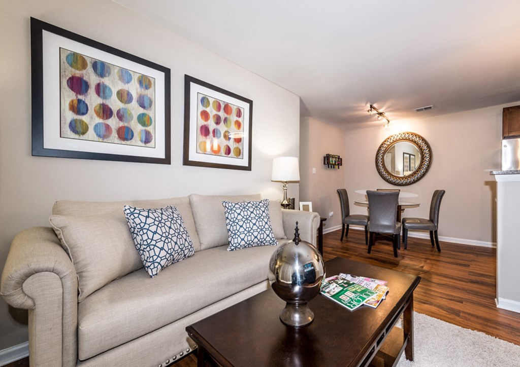 a living room with a couch coffee table and a dining room table in the background at Misty Ridge Apartments, Virginia, 22191
