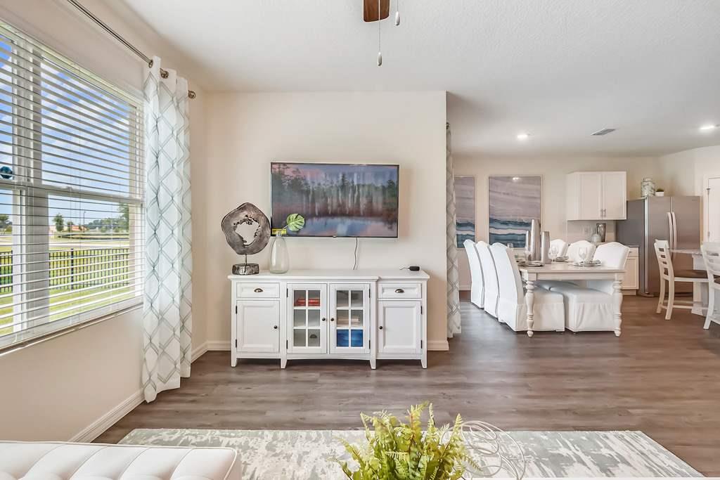 A living room with a white sofa and a painting on the wall.