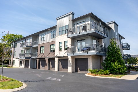 A large apartment building with a parking lot in front.