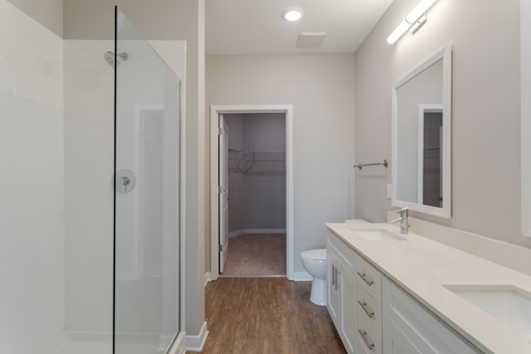 A bathroom with a walk-in shower, toilet, and sink.