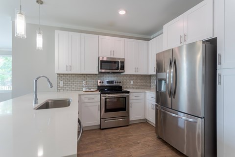 A modern kitchen with stainless steel appliances and white cabinets.