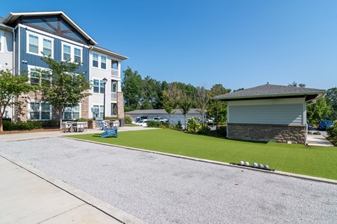 A large building with a blue and white exterior is surrounded by a well-maintained lawn and a clear blue sky.