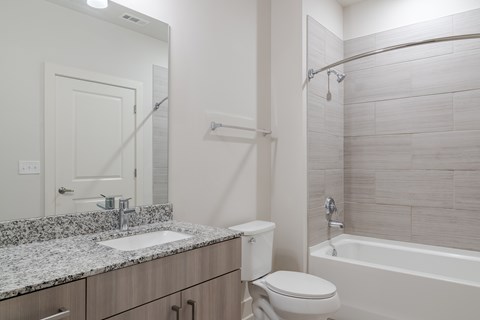 A bathroom with a sink, toilet, and bathtub.