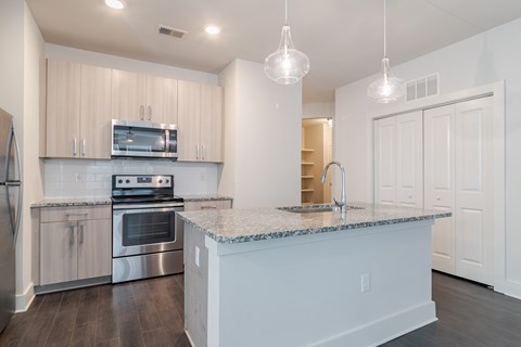 A kitchen with a granite countertop and stainless steel appliances.
