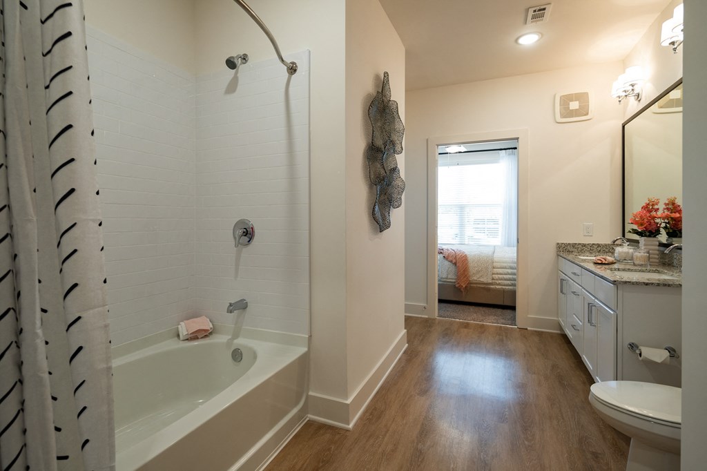 a bathroom with a tub and a sink and a toilet at The Quincy Apartments, Acworth, GA