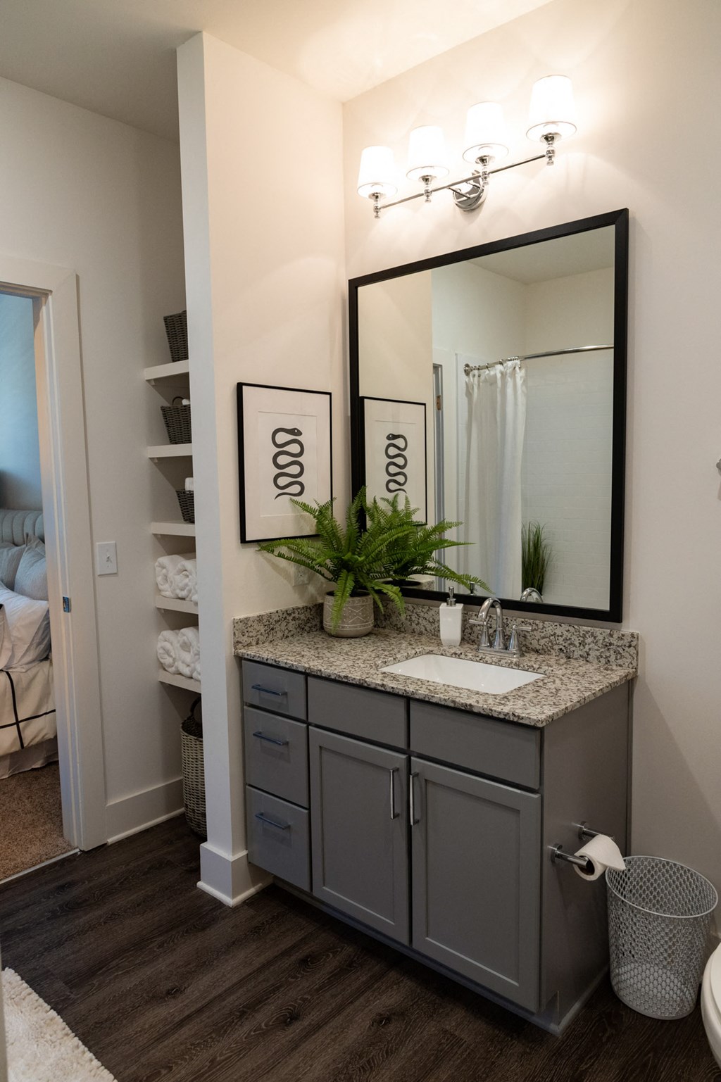 a bathroom with a sink and a mirror and a closet at The Quincy Apartments, Acworth, GA