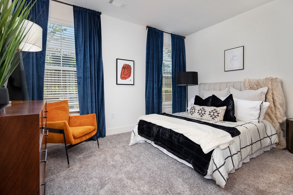 a bedroom with a bed and a desk with a chair at The Quincy Apartments, Acworth, GA, 30102