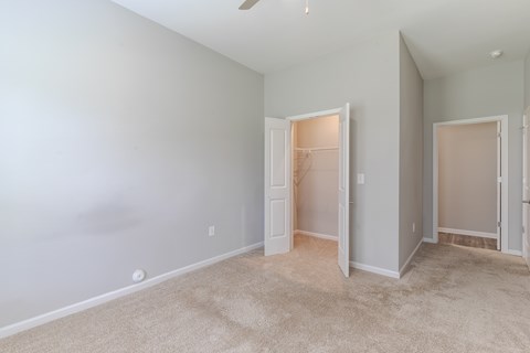 A room with a carpeted floor and two open doors.
