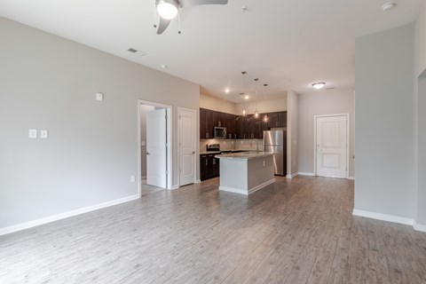 A spacious kitchen with a refrigerator, sink, and cabinets is visible.