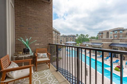 a balcony with a swimming pool and a patio with chairs at Residence at Riverwatch, Agusta