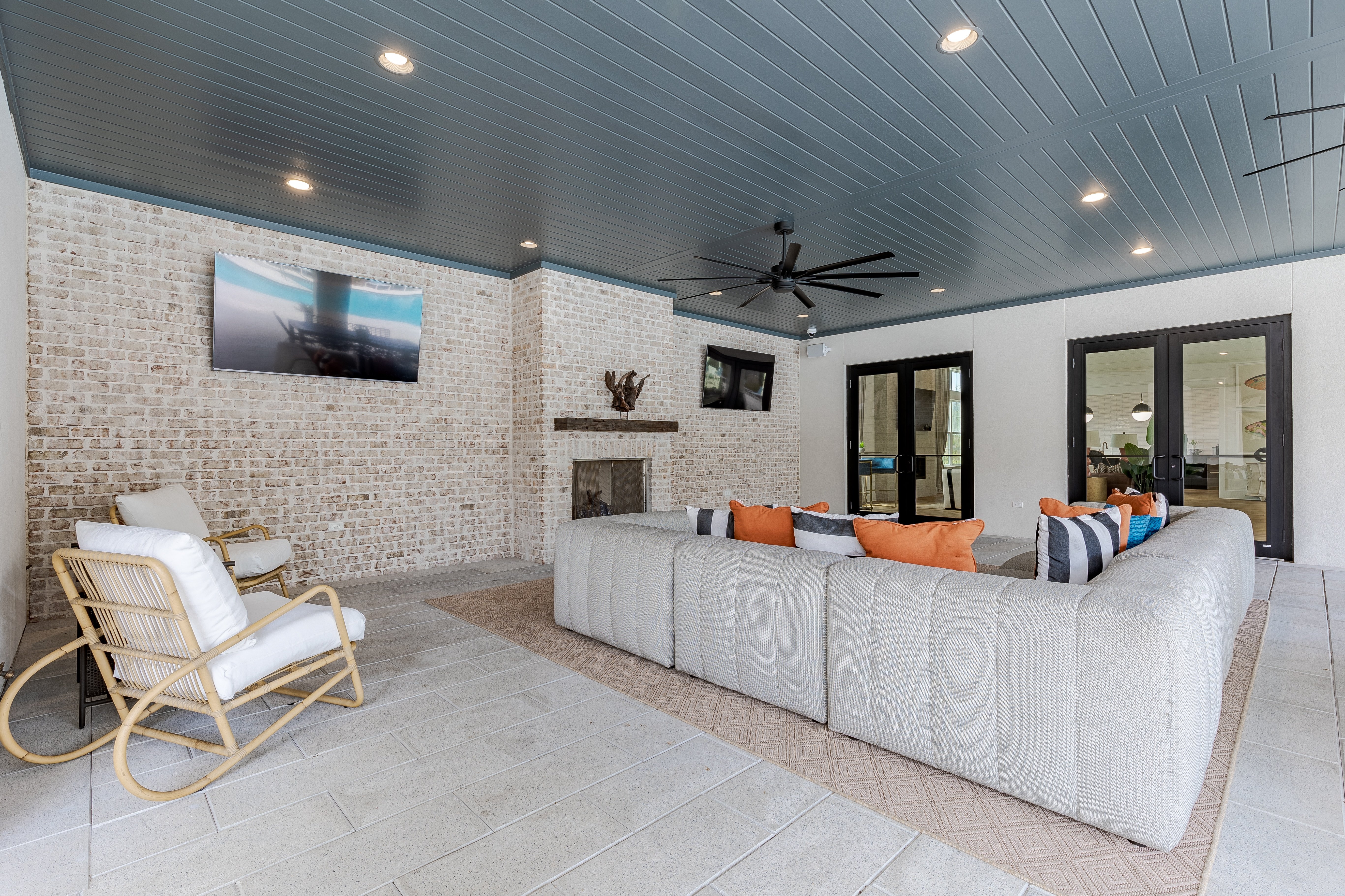 A living room with a white couch and a rocking chair.