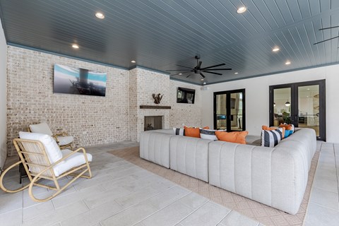 A living room with a white couch and a rocking chair.