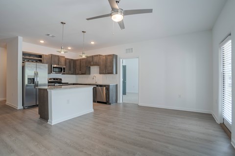 A modern kitchen with a white island and stainless steel appliances.