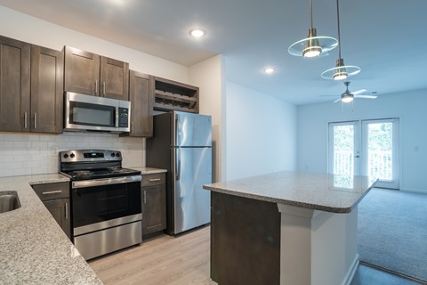 A kitchen with a refrigerator, stove, and microwave.