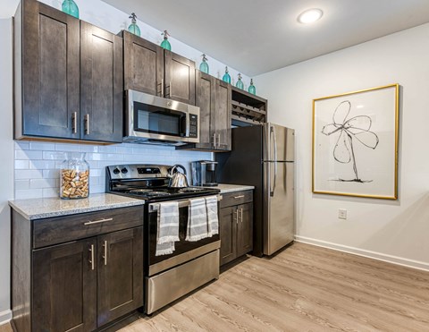 a kitchen with stainless steel appliances and wooden cabinets at Retreat at Arden Farms, Arden, NC