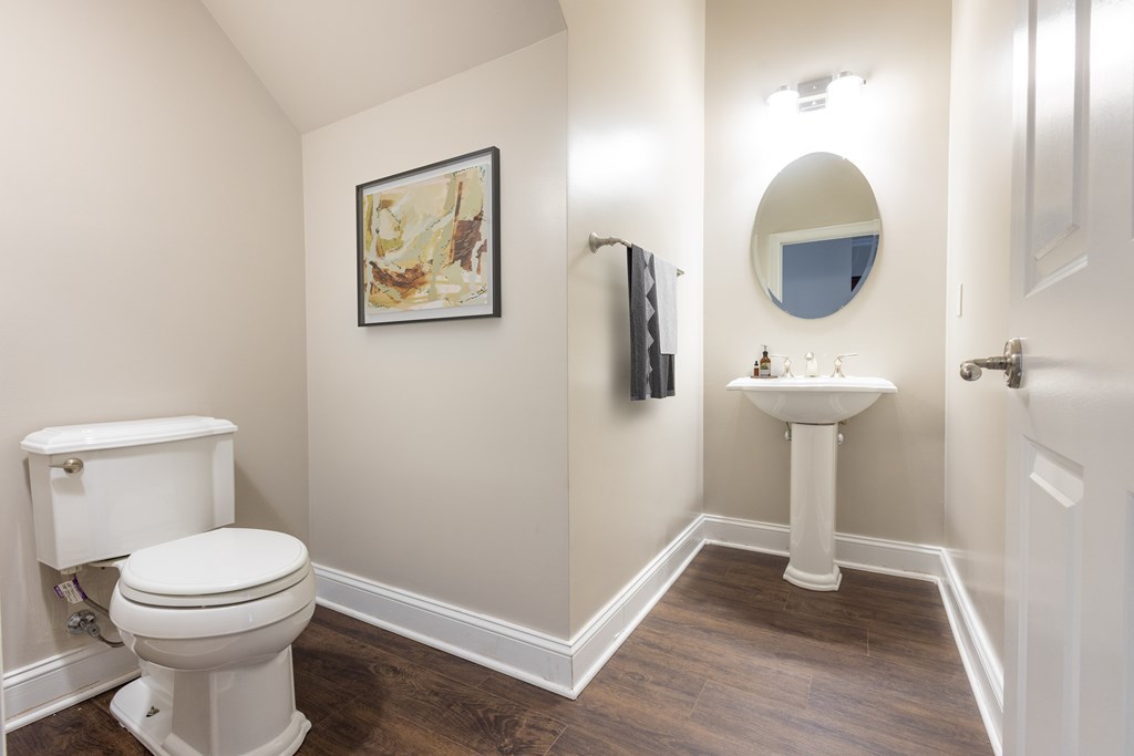 A bathroom with a toilet, sink, and mirror  at Sterling Manor, Williamsburg, VA