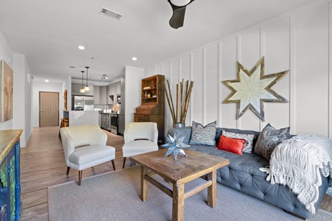 A living room with a grey couch and a wooden coffee table.