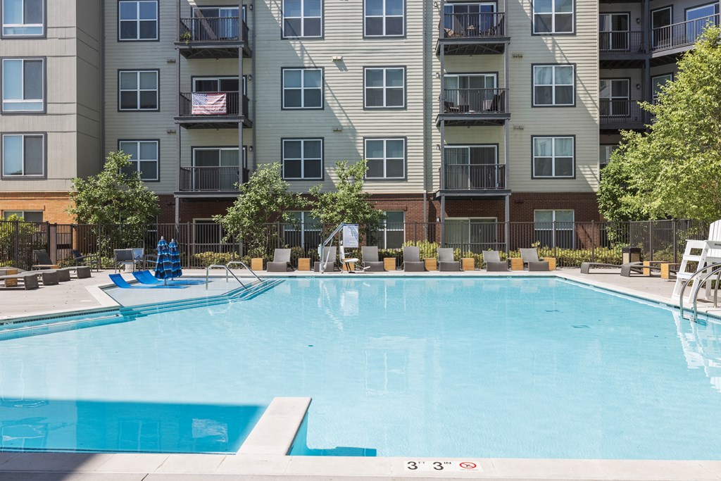 an outdoor pool with an apartment building in the background at Rivergate, Woodbridge, VA, 22191