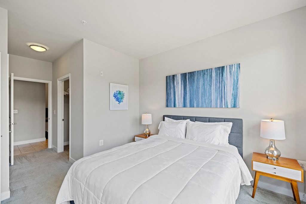 a bedroom with a large white bed and a blue painting on the wall at Rivergate, Woodbridge, Virginia