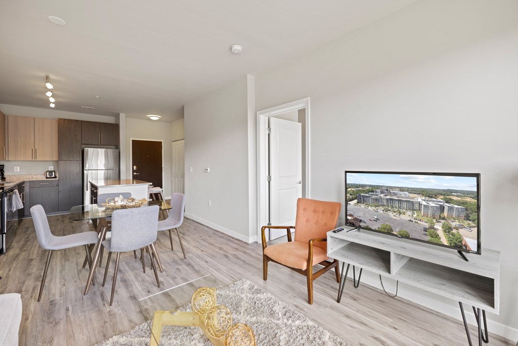 a living room with a tv and a dining room in the background at Rivergate, Woodbridge, Virginia