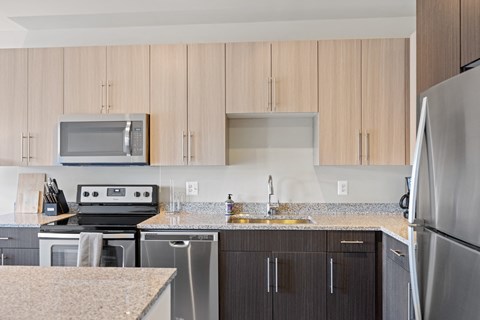 a kitchen with wooden cabinets and granite countertops at Rivergate, Woodbridge