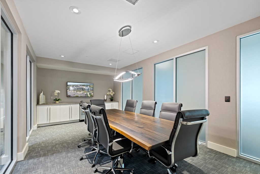 a conference room with a long wooden table and black chairs at Rivergate, Woodbridge