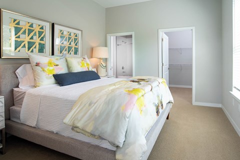 a bedroom with a bed and a door to a closet at One Riverside Apartments, Chattanooga