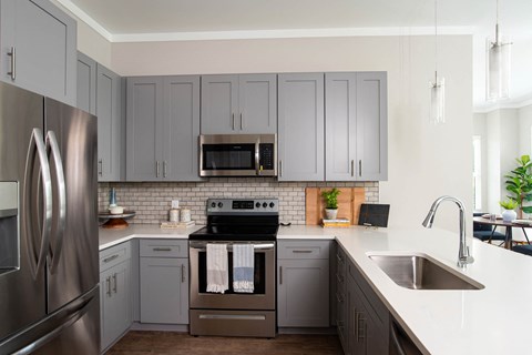 a kitchen with stainless steel appliances and gray cabinets