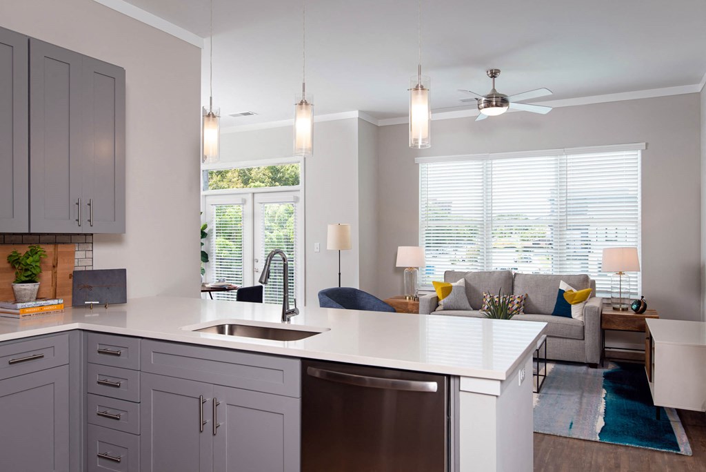 a kitchen with an island and a living room with a couch at One Riverside Apartments, Tennessee, 37403