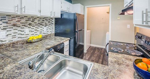 A kitchen with a granite countertop and stainless steel appliances.