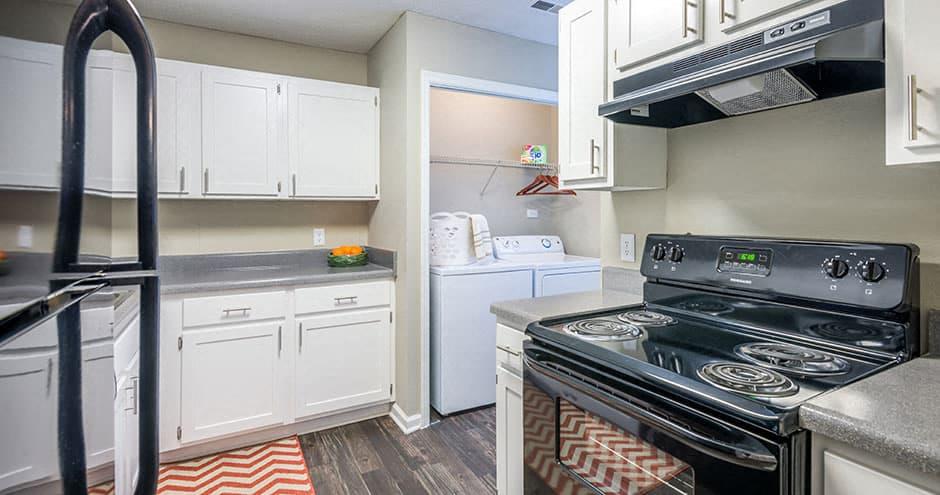 A kitchen with a black stove top oven and white cabinets.