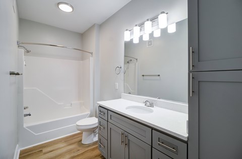A white bathroom with a toilet, sink, and mirror.