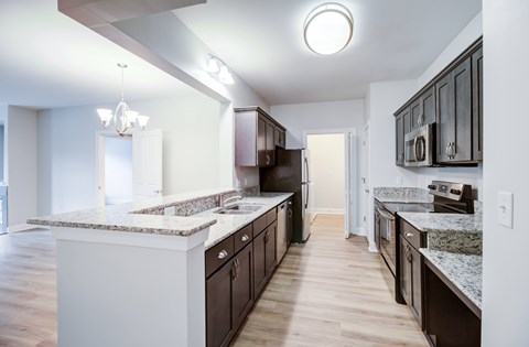 A kitchen with white and brown cabinets and a marble countertop.