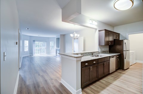 A kitchen with dark wood cabinets and a white island.