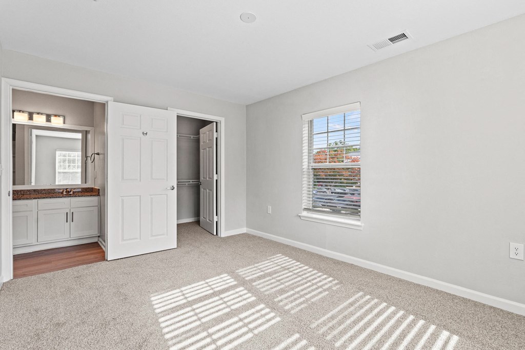 a renovated living room with a window and a door to a bathroom at SomerHill Farms Apartments, Gainesville Virginia
