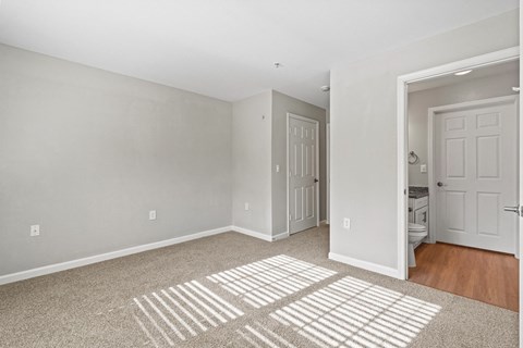 the living room of an apartment with a rug and a door to the bathroom at SomerHill Farms Apartments, Gainesville, 20155
