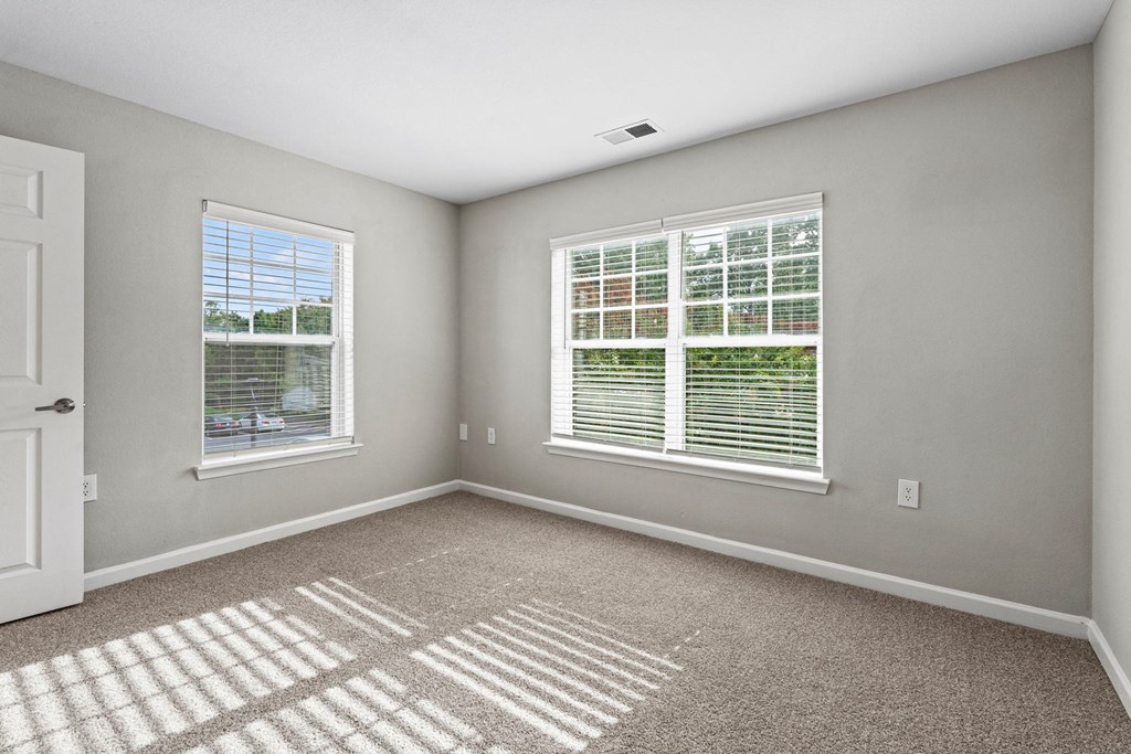 an empty room with two windows and a door at SomerHill Farms Apartments, Gainesville, 20155