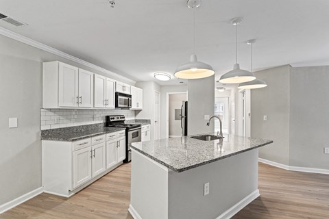 a kitchen with white cabinets and a marble counter top at SomerHill Farms Apartments, Gainesville, VA 20155