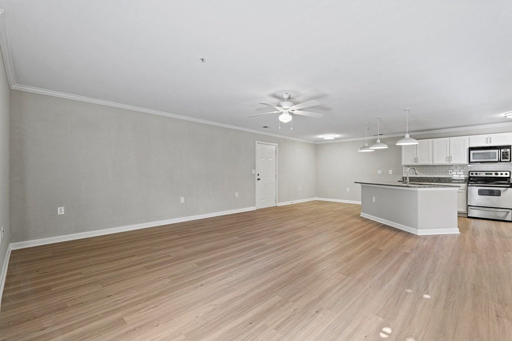 the living room and kitchen of a new home with wood flooring at SomerHill Farms Apartments, Gainesville