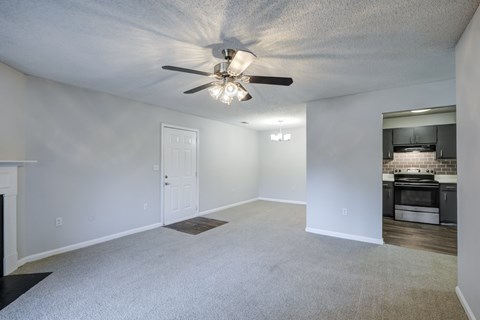 A spacious room with a ceiling fan and a fireplace.