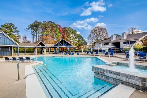 A large swimming pool with a fountain in the middle of it.