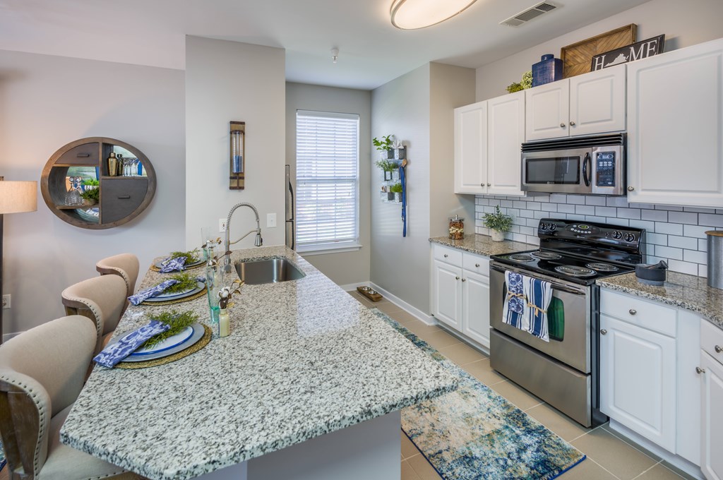 A kitchen with granite countertops and white cabinets  at Sterling Manor, Williamsburg