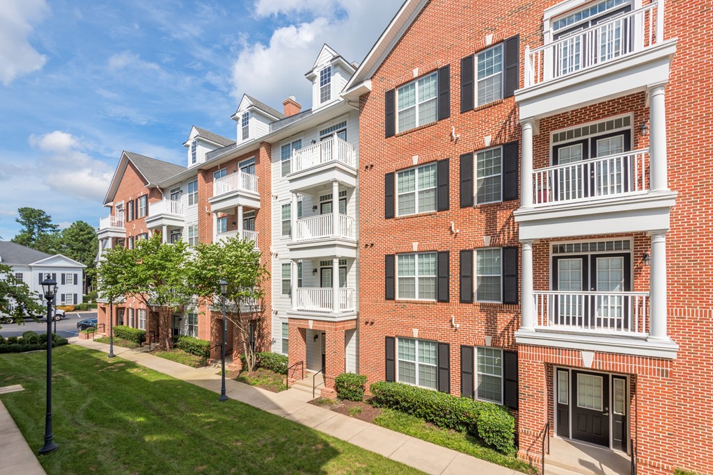 A red brick apartment building with white balconies and black shutters  at Sterling Manor, Williamsburg, Virginia