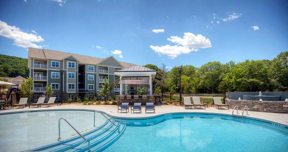a swimming pool with chairs and a building in the background  at Lullwater at Big Ridge, Hixson, Tennessee